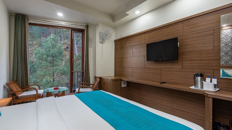 A bedroom featuring a seating area with a table and two chairs near the window at DLS Hotels The Rock Castle.
